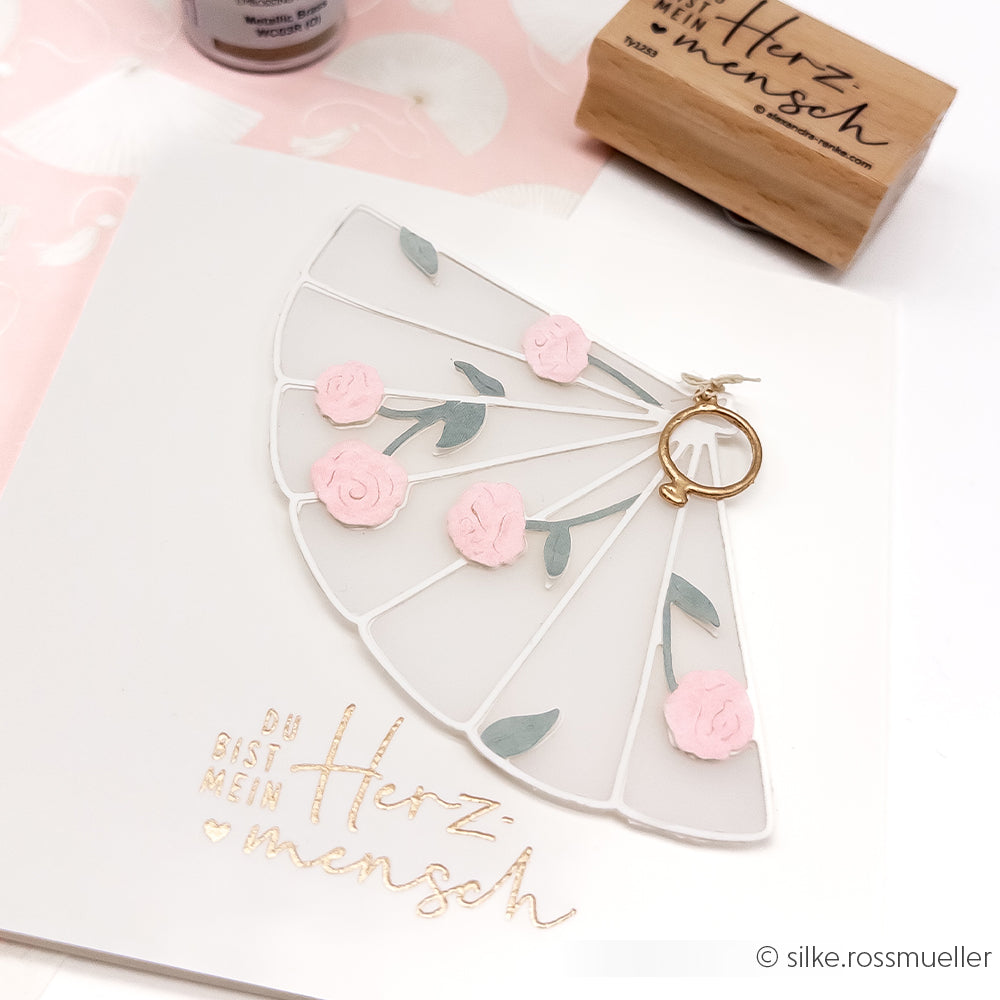 Eine handgefertigte Karte mit einem Fächermotiv aus der Alexandra Renke Motivstanze Blumiger Fächer, verziert mit rosafarbenen Blumen und deutscher Kalligraphie mit der Aufschrift Du bist mein Herzmensch".