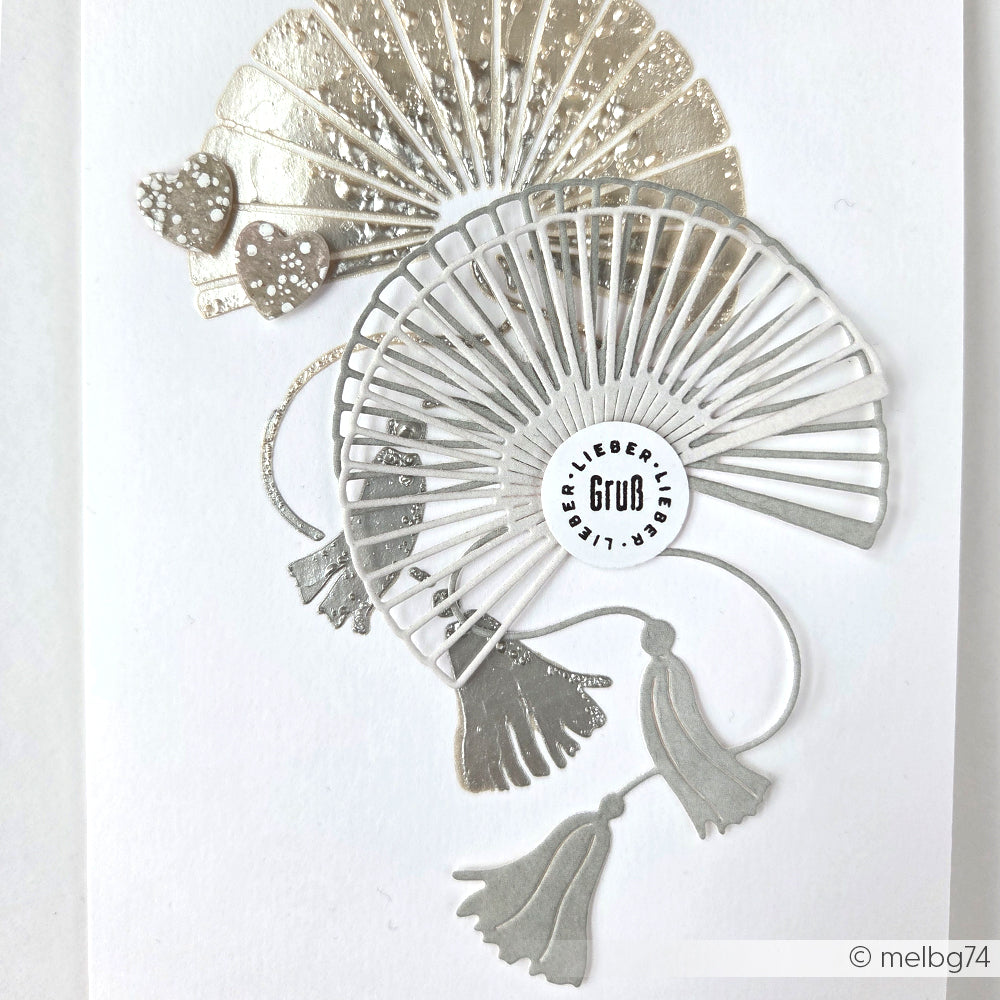 Silberne und metallische Papierfächer mit Quasten, mit kreisförmigem GUB LIEBERT-Schriftzug auf Weiß, hergestellt von Alexandra Renke mit dem DieCut System aus 100% Stahl - ideal als Motivstanze Großer Fächer für einzigartige Designs.