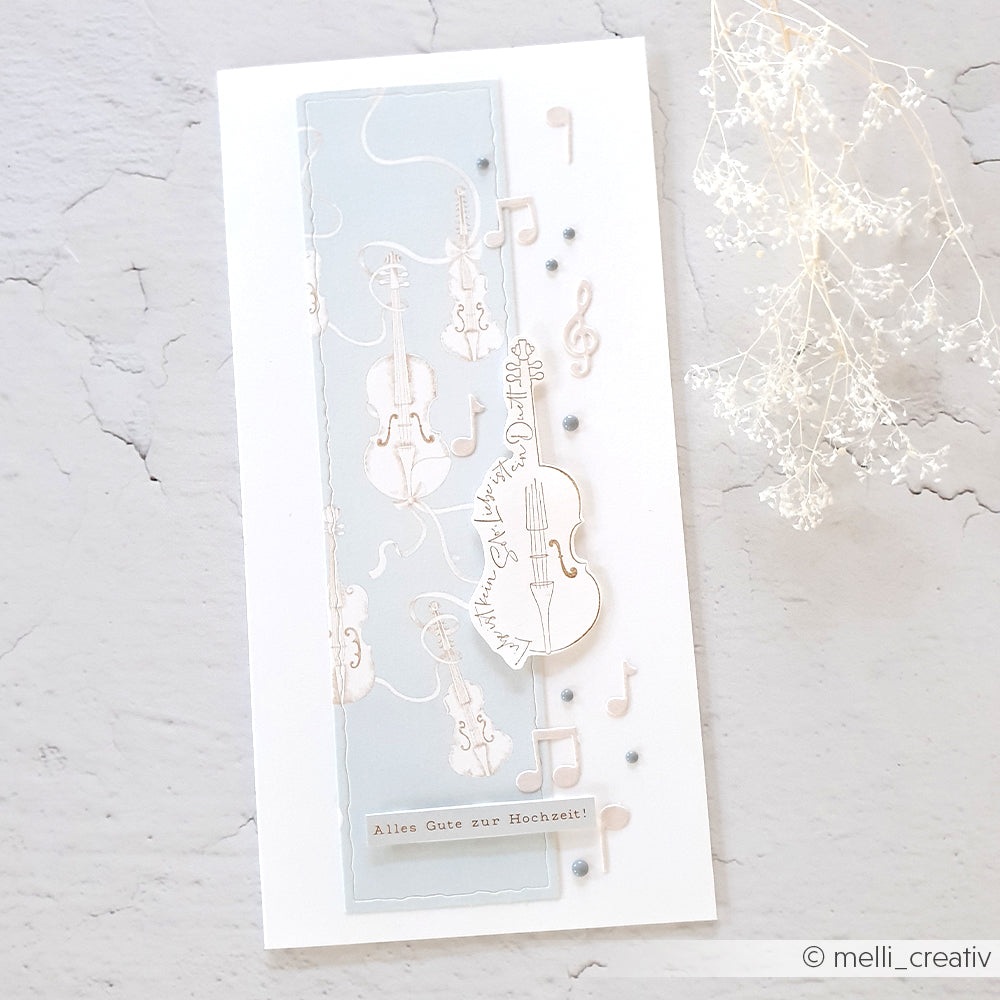 Handgefertigte Hochzeitskarte von Alexandra Renke mit Musikinstrumenten, Noten, dem Spruch "Alles Gute zur Hochzeit!" und einzigartigen gestanzten Designelementen für einen eleganten Touch.