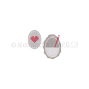 Die beiden ovalen Stickaufnäher von Alexandra Renke zeigen ein rotes Herz und eine Nadel auf einem grauen Rahmen. Hergestellt mit dem Motivstanze Stickrahmen Oval DieCut Systeme sind sie perfekt, um Ihren Designpapieren Charme zu verleihen.