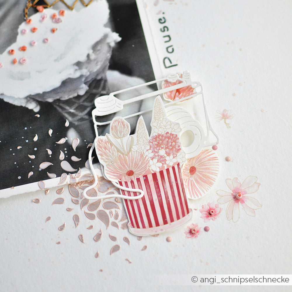 Foto einer Scrapbook-Seite mit einem Blumenausschnitt, einem gestreiften Blumentopf und einem Ausschnitt aus einem Eisfoto, gestaltet mit der Motivstanze „Kamera Outline“ und passenden Designpapieren für zusätzliche Struktur und Details.