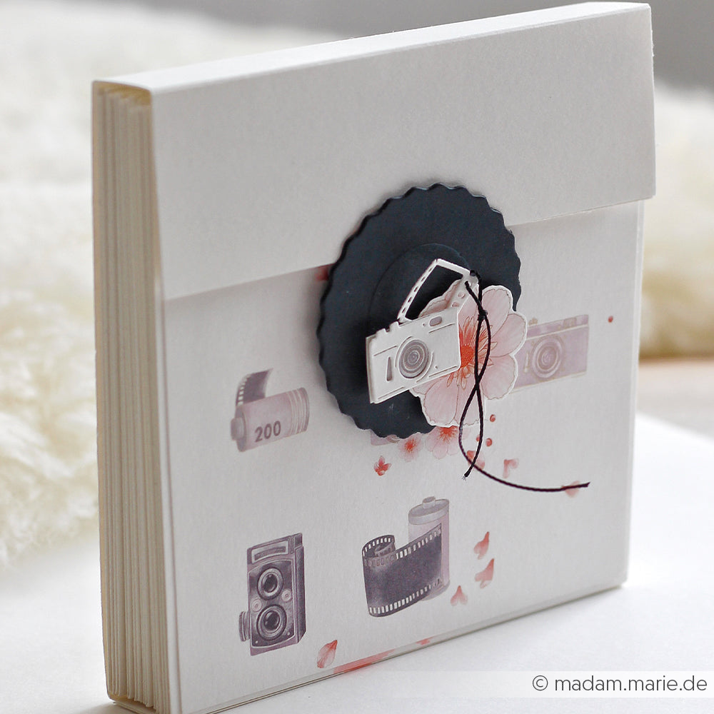Quadratischer Umschlag mit Vintage-Kamera-Motiven und einem schwarzen Siegel, verziert mit einer Blume und einer Schnur – ideal in Kombination mit den „Motivstanze Foto-Anhängern“ oder Ihren Lieblings-Designpapieren für eine ganz persönliche Note.