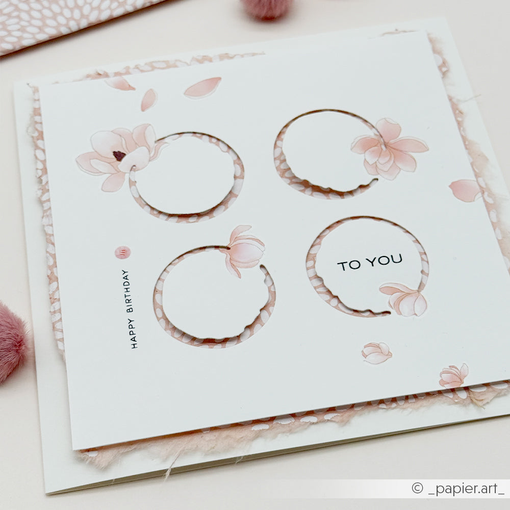 Eine quadratische Blumenkarte von Alexandra Renke mit vier runden Ausschnitten, zarten rosa Blumen und den Schriftzügen „TO YOU“ und „HAPPY BIRTHDAY“. Diese Karte wurde mit Hilfe von DieCut-Systemen präzise gefertigt und mit wunderschönen Designpapieren verziert – die perfekte Art, jemandem an seinem besonderen Tag eine Freude zu bereiten.