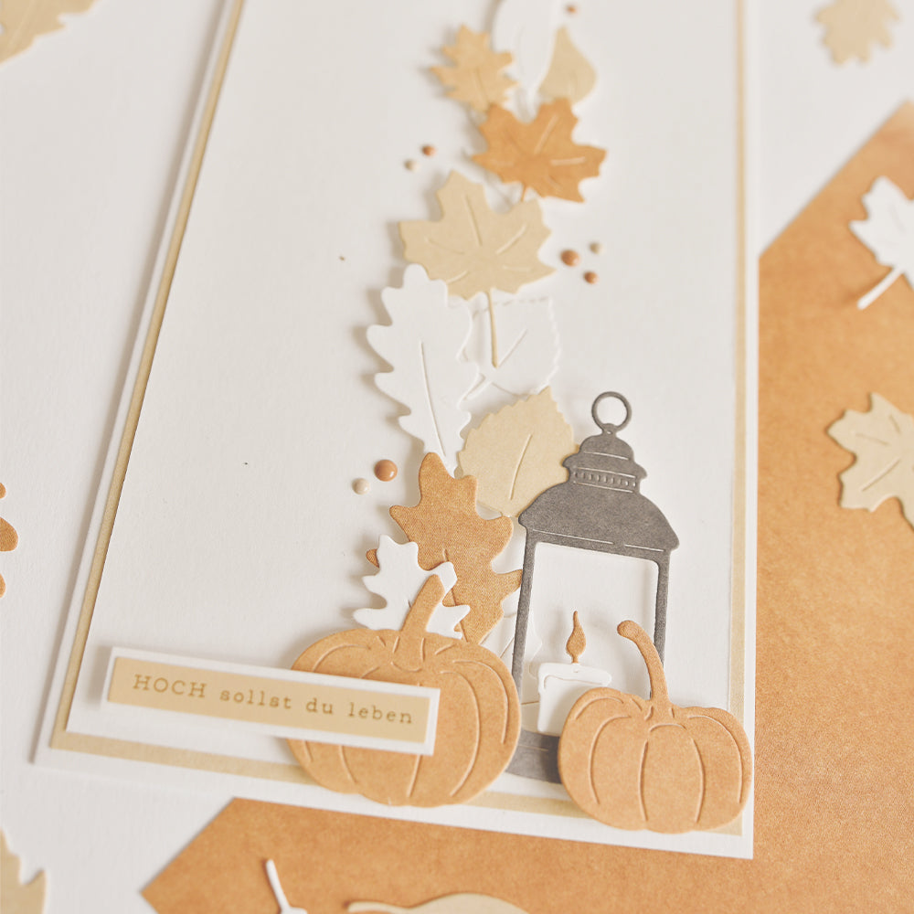 Eine Karte zum Thema Herbst mit bezaubernden Papierkürbissen, die mit der Motivstanze „Kürbis“ gestaltet wurden, einer zarten Laterne, Herbstblättern und einem deutschen Spruch auf strahlend weißem Hintergrund. Dieses Design eignet sich perfekt für saisonale Grüße und zeigt auf wunderschöne Weise, welche kreativen Möglichkeiten sich mit DieCut-Systemen und farbenfrohen Designpapieren bieten.