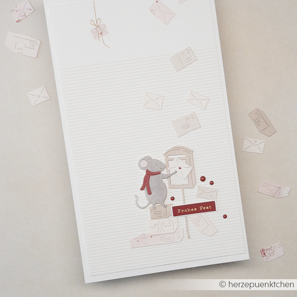 Eine Maus mit rotem Schal wirft einen Brief in einen Briefkasten auf Briefpapier von designpapiere.