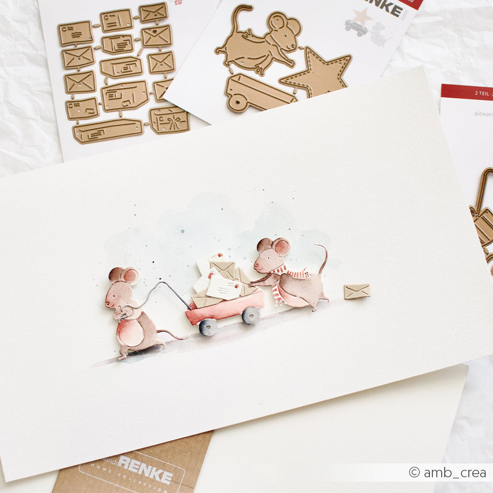 Aquarellillustration von zwei Mäusen, die einen roten Wagen ziehen, der mit Umschlägen aus Designpapier gefüllt ist.