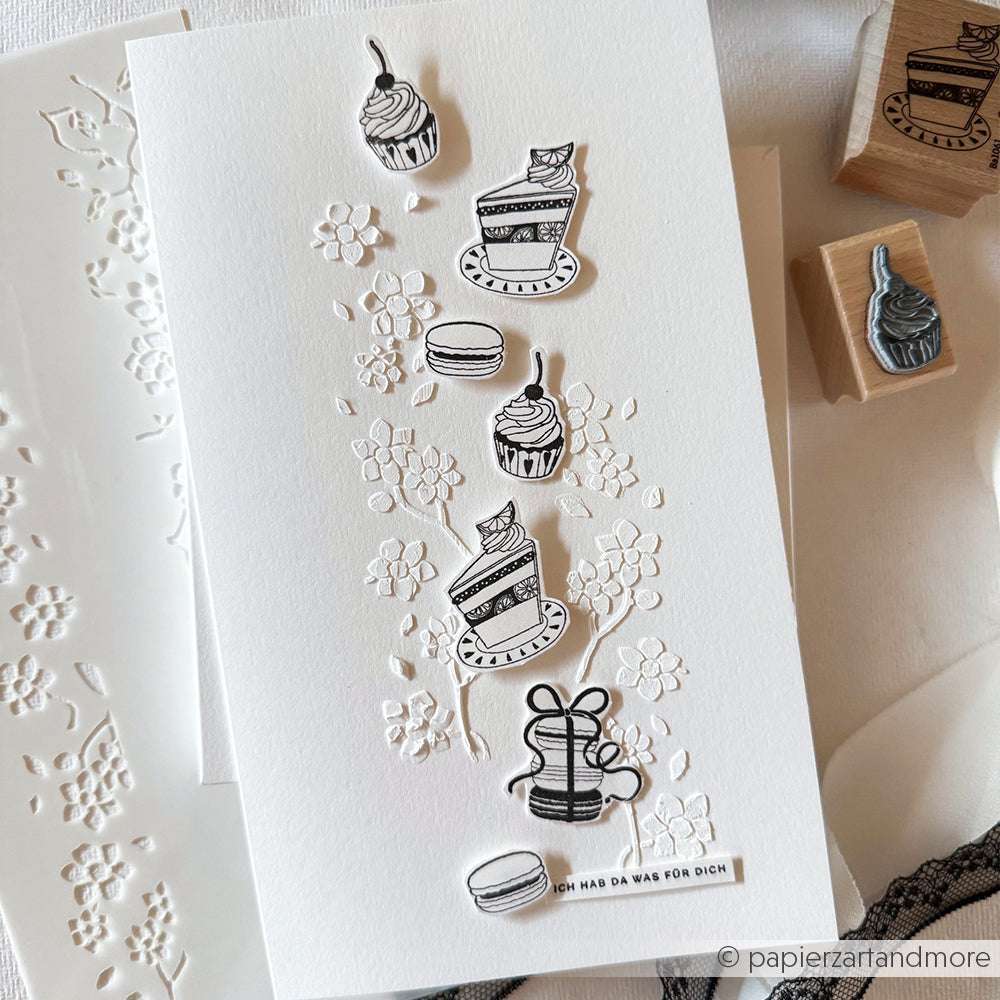 Handgefertigte Karte mit geprägten Blumen und schwarz-weißen Torten-, Cupcake-, Geschenk- und Macaron-Ausschnitten - wunderschön akzentuiert mit detaillierten Stempelmotiven, die mit Alexandra Renke Stempelgummi oder Holzstempel hergestellt wurden.
