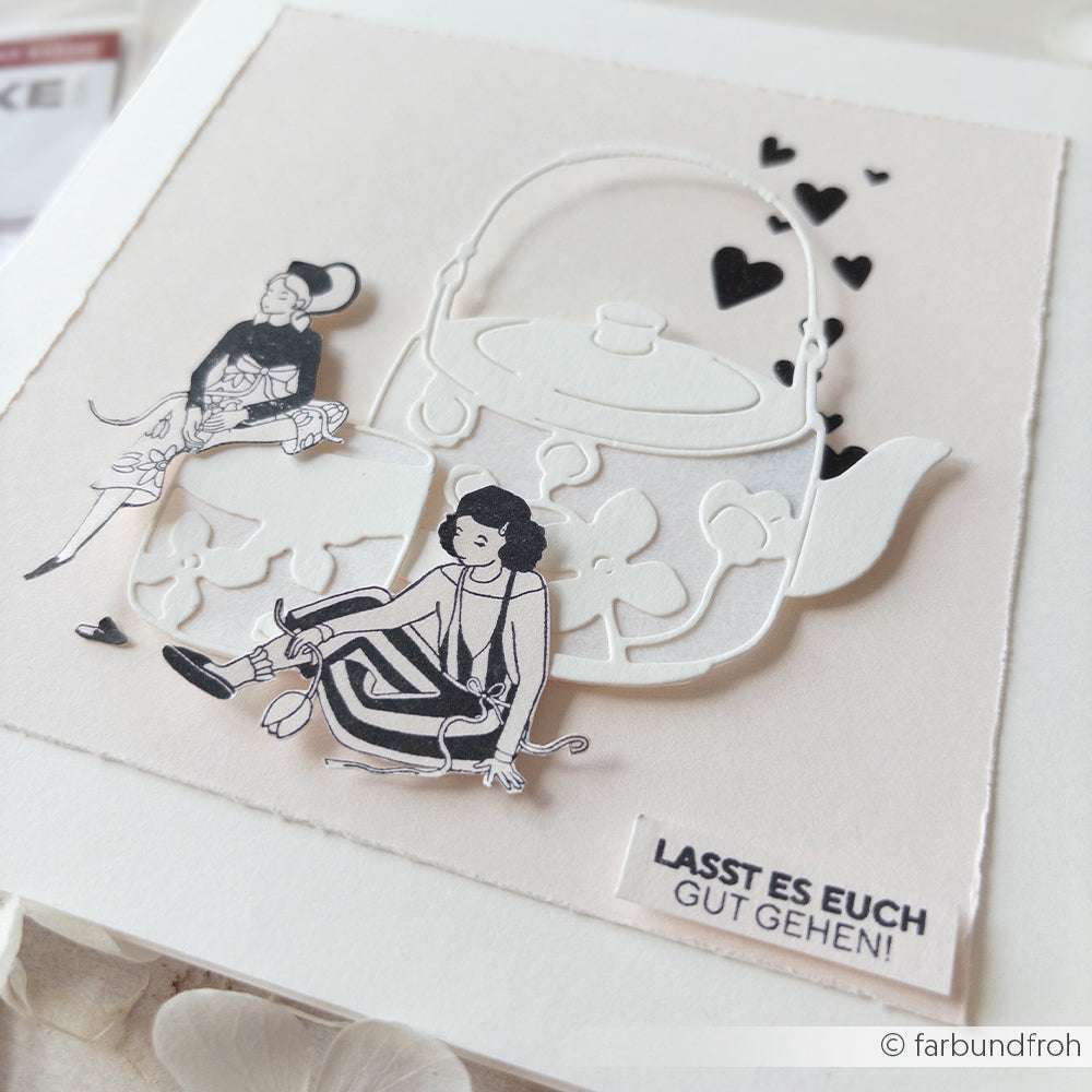 Handgefertigte Karte von Alexandra Renke mit zwei illustrierten Frauen, dem Umriss einer Teekanne und dem Text LASST ES EUCH GUT GEHEN! mit handwerklichen Details, inspiriert von Stempel aus Holz.