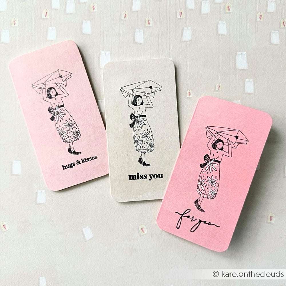 Drei Karten von Alexandra Renke zeigen charmante Illustrationen einer Frau mit Regenschirm und süßen Botschaften - Umarmungen und Küsse, vermisse dich, für dich - ideal für Papierprojekte oder in Kombination mit Ihren Lieblingsstempelkissen.