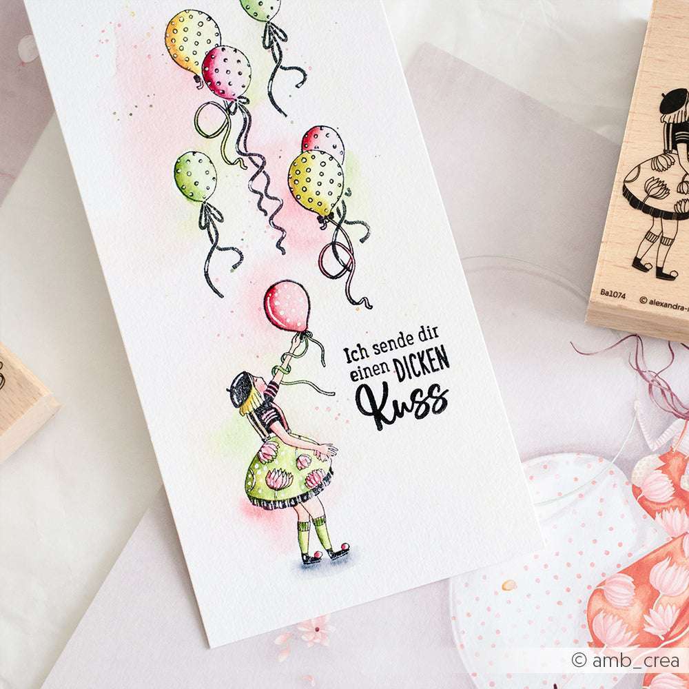 Eine handgezeichnete Karte von Alexandra Renke zeigt ein Kind mit Luftballon und den Text "Ich sende dir einen DICKEN Kuss", verziert mit charmanten Briefmarkenmotiven.