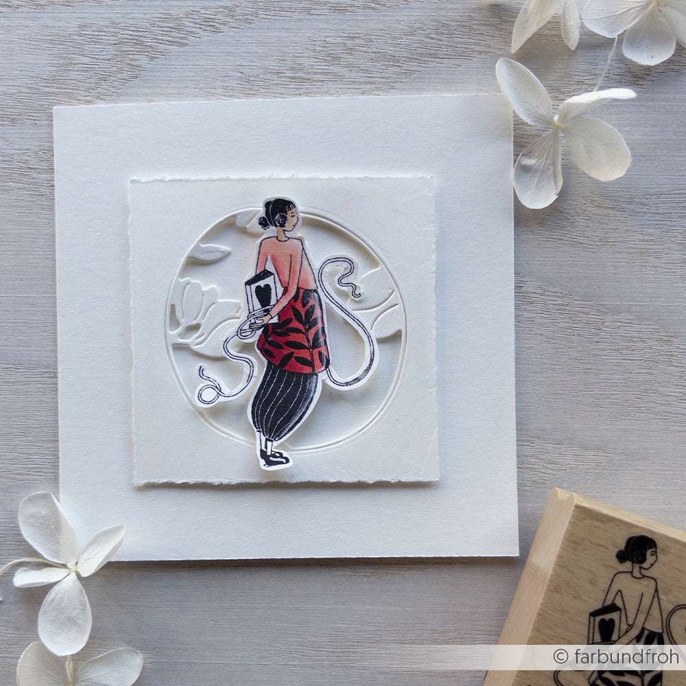 Eine handgemachte Karte von Alexandra Renke mit einem Ausschnitt einer Frau in einem rot-schwarzen Kleid mit weißen Blumendetails, perfekt für Papierprojekte und inspiriert von Bücher-Figurinen Kind Designs.