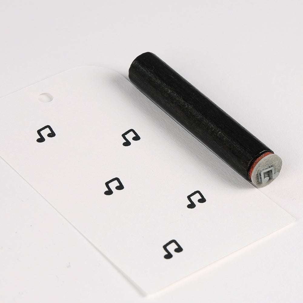 Ein Notenstempel und ein Anhänger, gestempelt mit mehreren schwarzen Noten - perfekt für Alexandra Renke als Akzent für Papierprojekte oder als einzigartiger Akzent-Stempel beim kreativen Basteln.