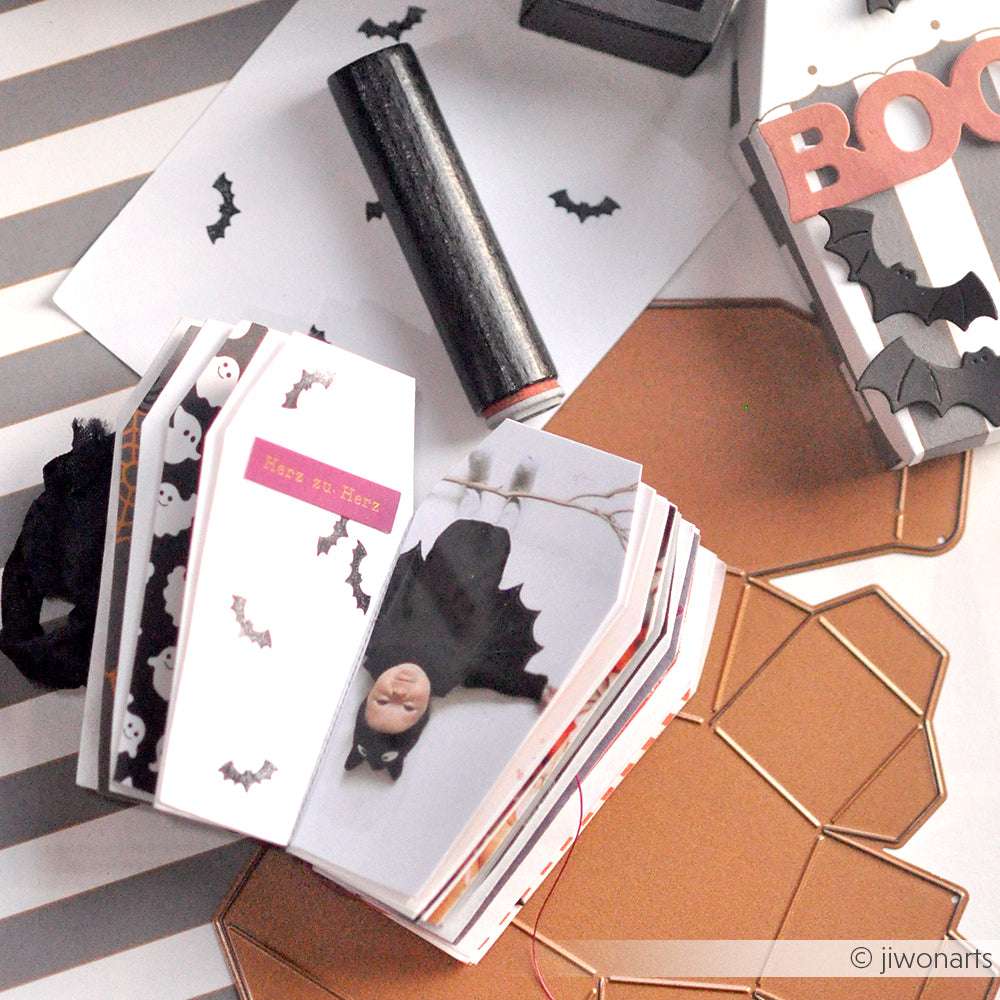 Die handgefertigten Halloween-Papierbasteleien von Alexandra Renke, darunter eine Karte in Fledermausform und eine BOO-Schachtel mit Fledermäusen und Sargmotiven, zeichnen sich durch charmante Akzent-Stempel-Details und einen Mini-Geist mit Hut aus, der für zusätzliches Gruselflair sorgt.
