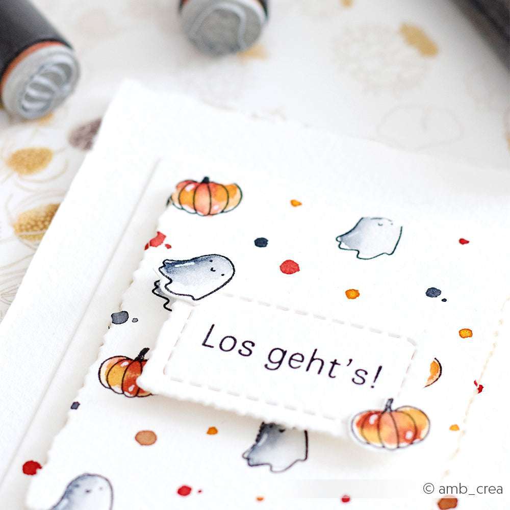 Eine Karte von Alexandra Renke mit niedlichen Gespenster- und Kürbisillustrationen, Stempelmotiven und "Los geht's!" auf einem gestickten Etikett - perfekt, um Ihren Lieblings-Holzstempeln eine verspielte Note zu verleihen.