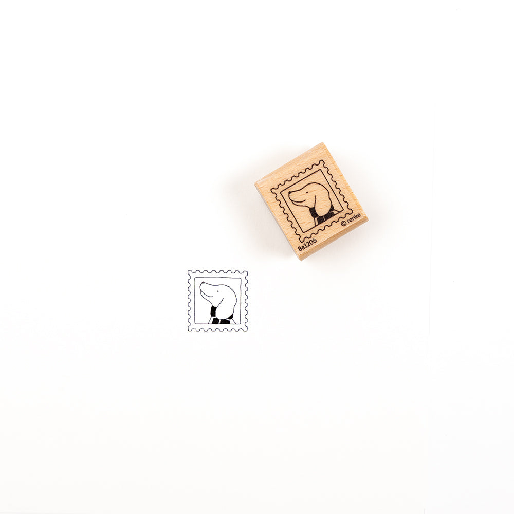 Ein Dackel-Stempel aus Holz mit dem Profil eines Hundes und dem dazugehörigen Stempelabdruck auf weißem Papier.