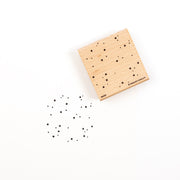 Ein auf Holz montierter Stempelgummi mit einem Sternenfeldmuster und einem Muster des Motivs, das darunter abgestempelt ist.