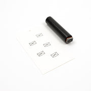 Ein schwarzer Holzstempel neben einem Anhänger mit fünf gestempelten „Mini-Brief mit Stern“-Symbolen.