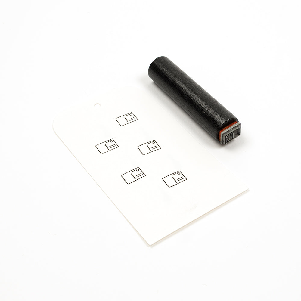 Ein schwarzer Akzentstempel aus Gummi und eine Karte, auf der fünf kleine Briefumschlagsymbole aufgestempelt sind.