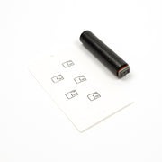Ein schwarzer Akzentstempel aus Gummi und eine Karte, auf der fünf kleine Briefumschlagsymbole aufgestempelt sind.