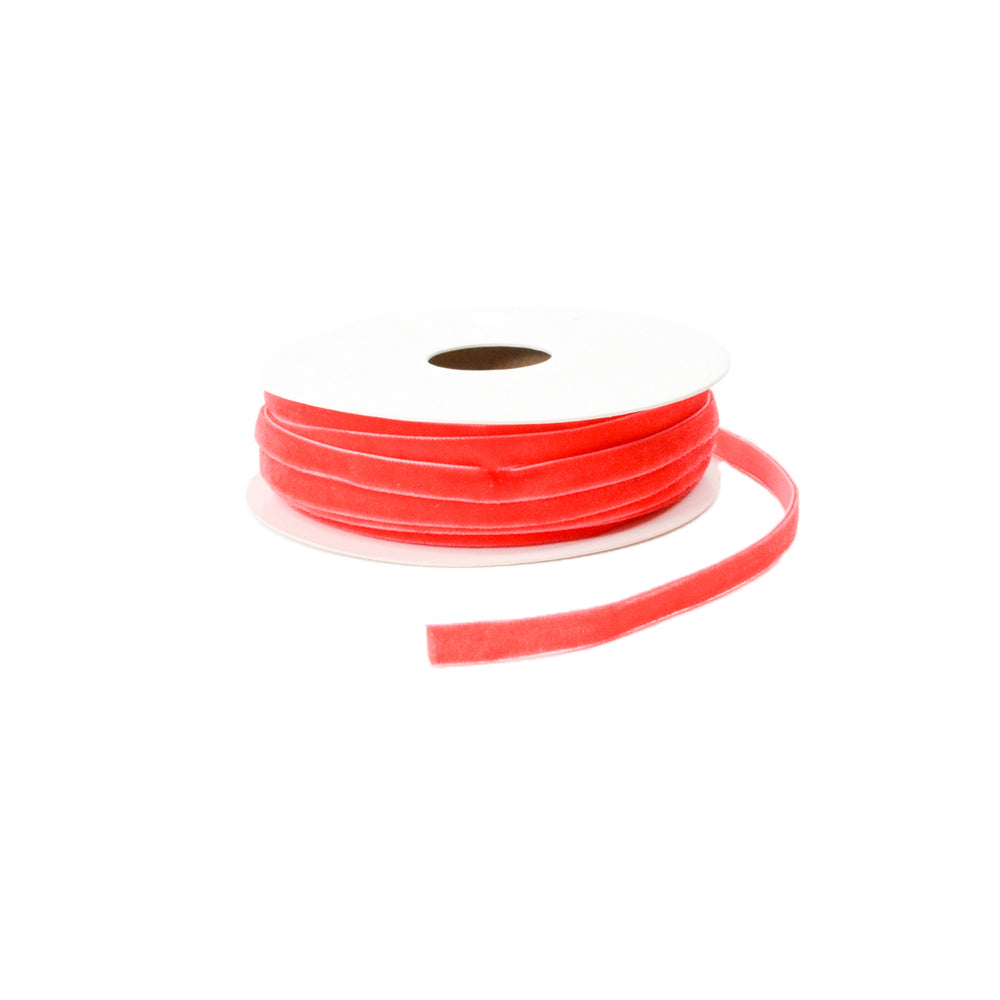 Eine Spule mit rotem Samtband von Vivant Decorations BV mit abgewickeltem Band liegt auf weißem Hintergrund.