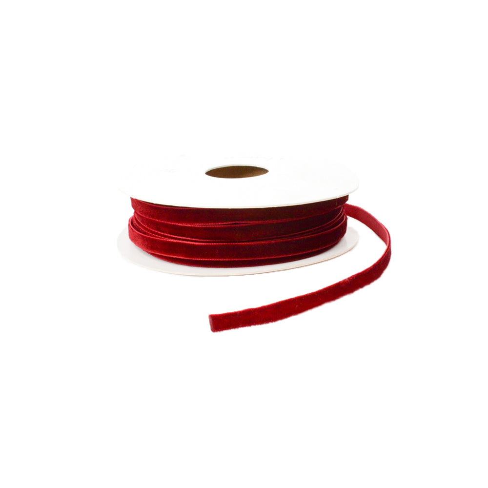 Eine Spule Vivant Decorations BV rotes Samtband (Samtband) mit abgewickeltem Band, dargestellt vor einem weißen Hintergrund.