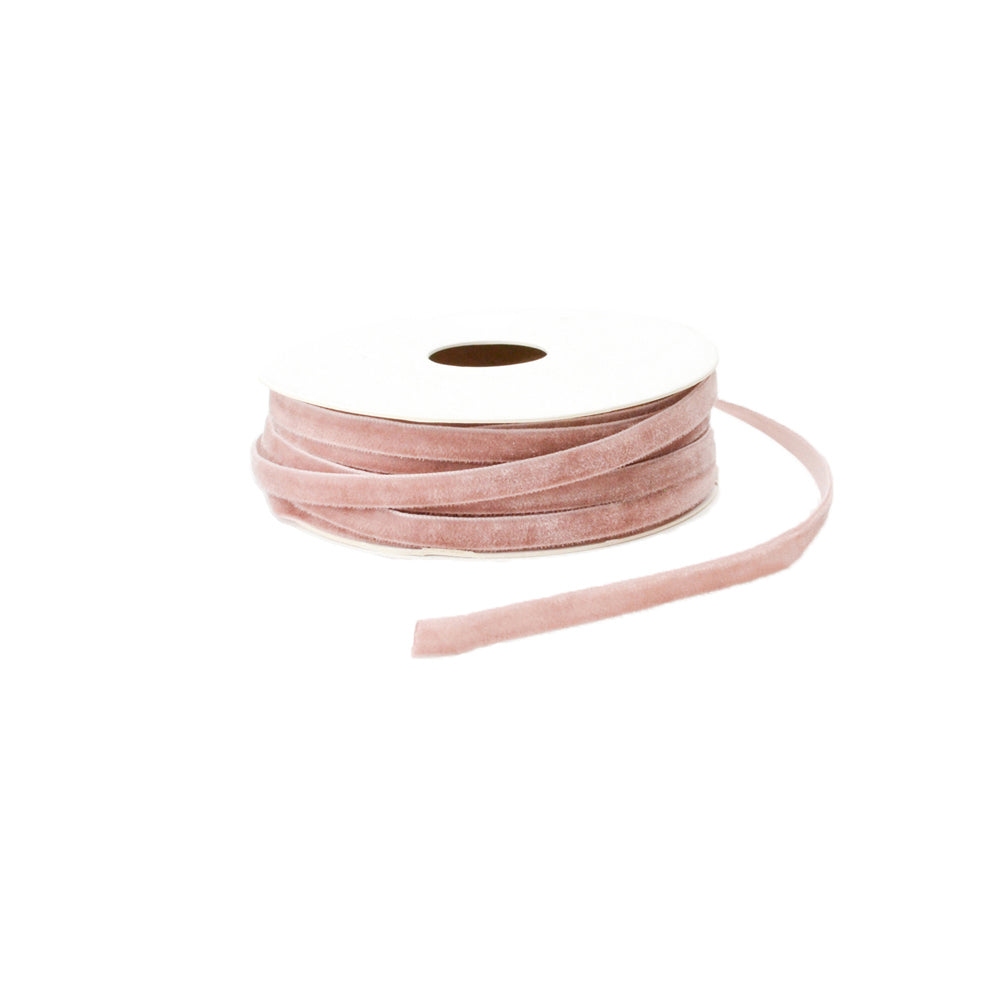 Eine Spule mit staubrosa Samtband von Vivant Decorations BV, teilweise aufgerollt, liegt anmutig auf einem weißen Hintergrund.