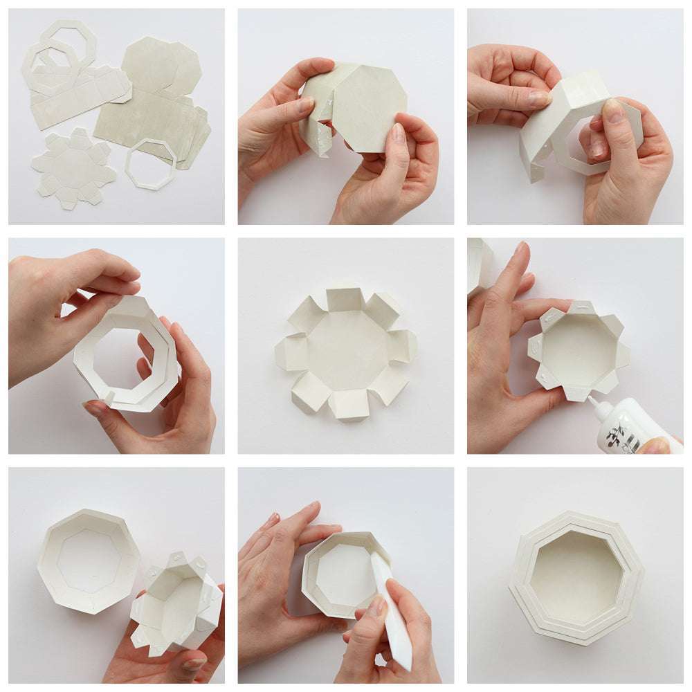 Eine Schritt-für-Schritt-Anleitung zeigt, wie man mit der Alexandra Renke Motivstanze Achteckbox weißes Papier faltet und klebt, um eine kleine achteckige Schachtel herzustellen.