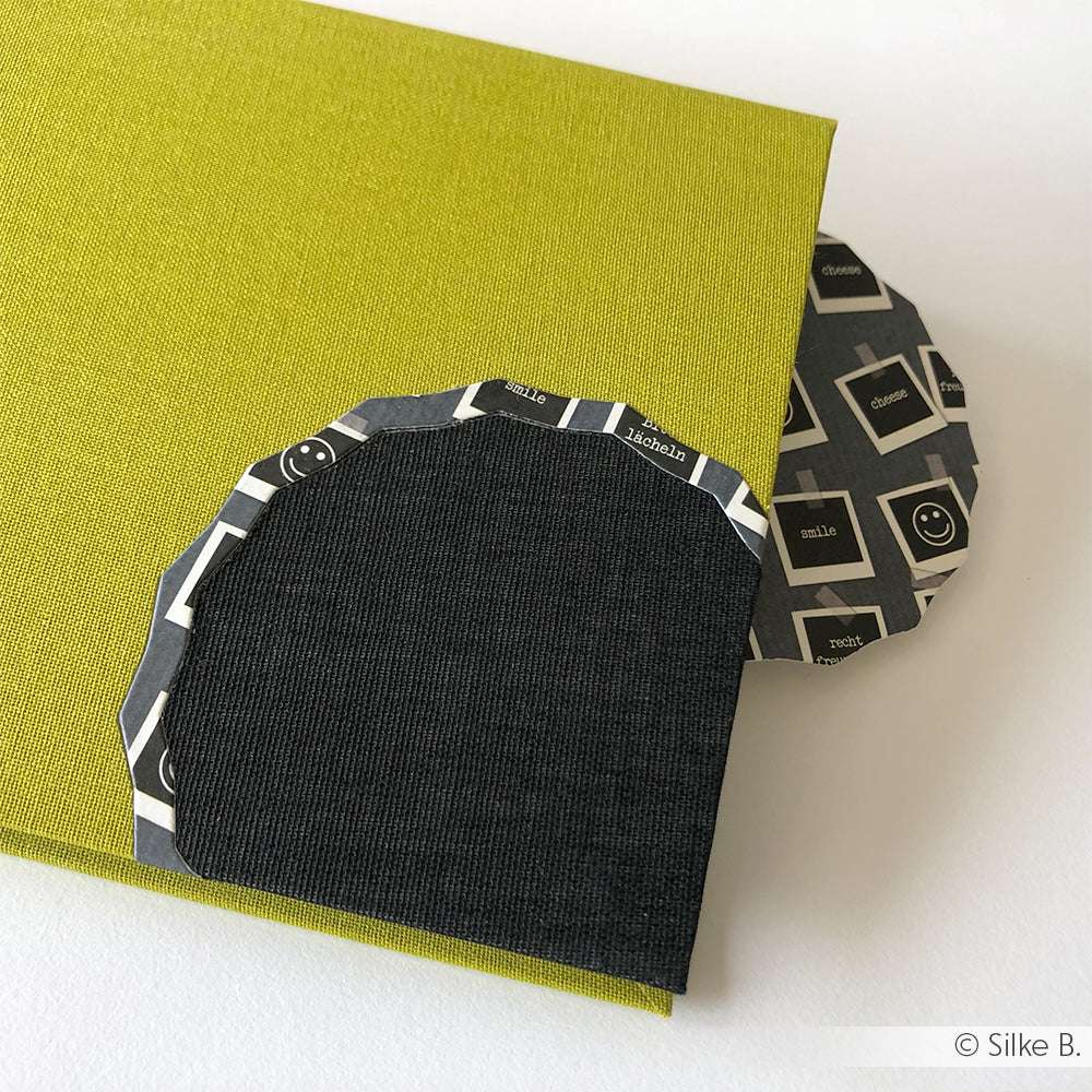 Ein grünes Buchleinenbuch von ☆ mit einem schwarz-weißen abgerundeten Lesezeichen oben rechts zeigt klimaneutrale Werte und einen Hauch von französischem Lifestyle.