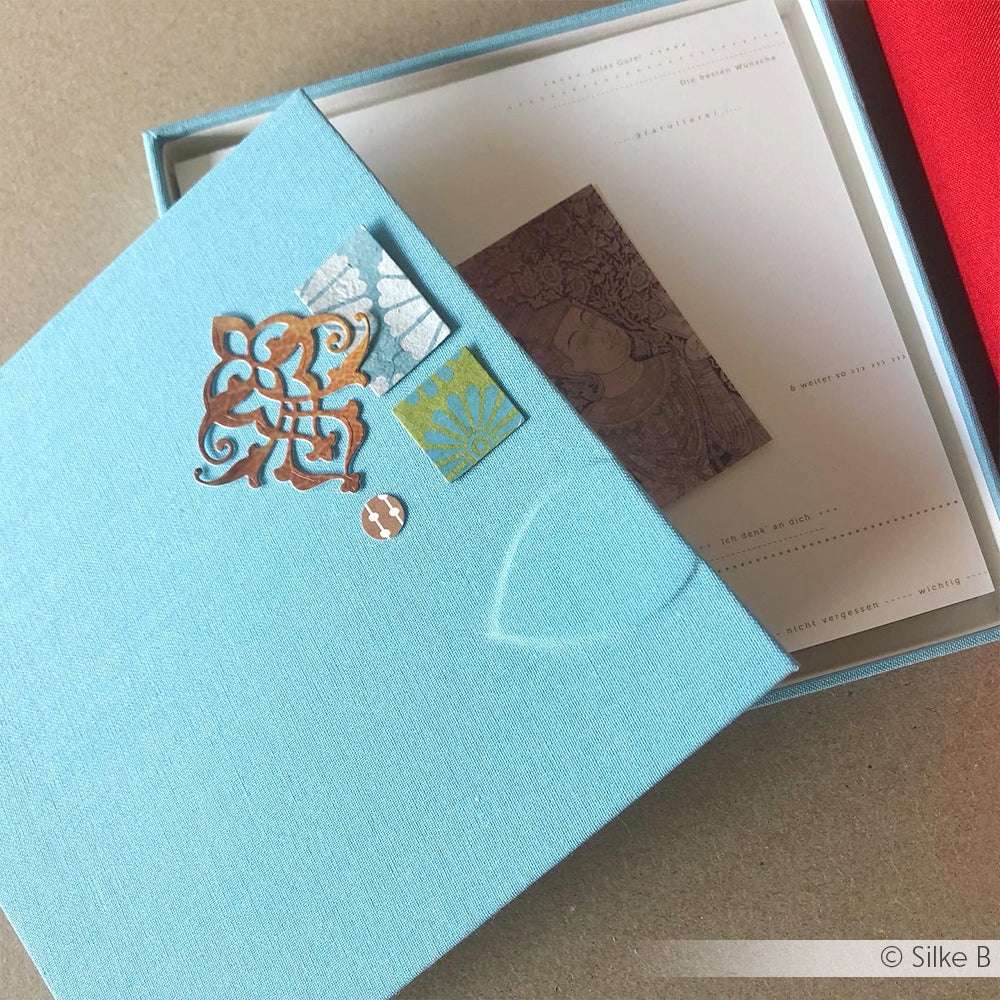 Eine ☆ blaue Buchleinenschachtel mit aufwendigen Verzierungen enthält Karten von Offsetdruck und ist innen mit einem kleinen braunen Druck versehen.