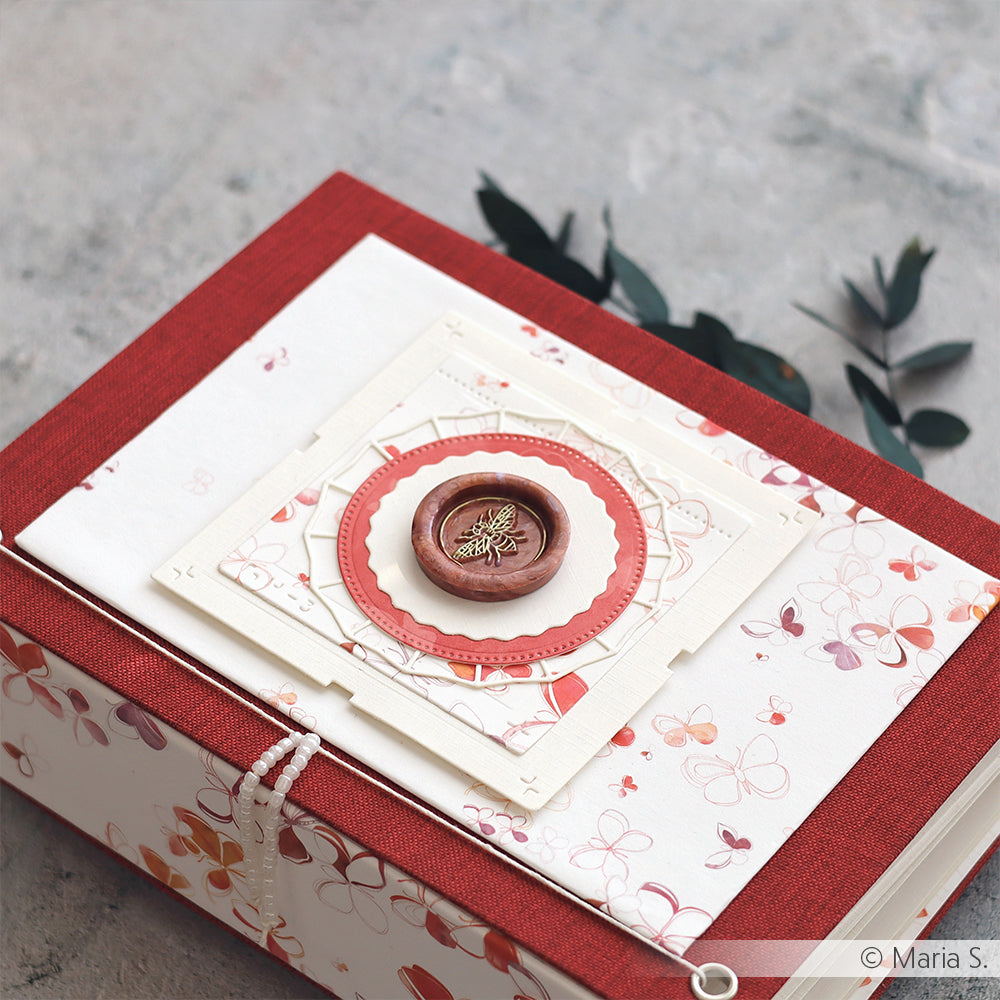 Eine ☆ dekorative Schachtel aus elegantem Buchleinenstoff mit rotem Rand, Schmetterlingsmuster und einem mit Blattgold verzierten Wachssiegel.