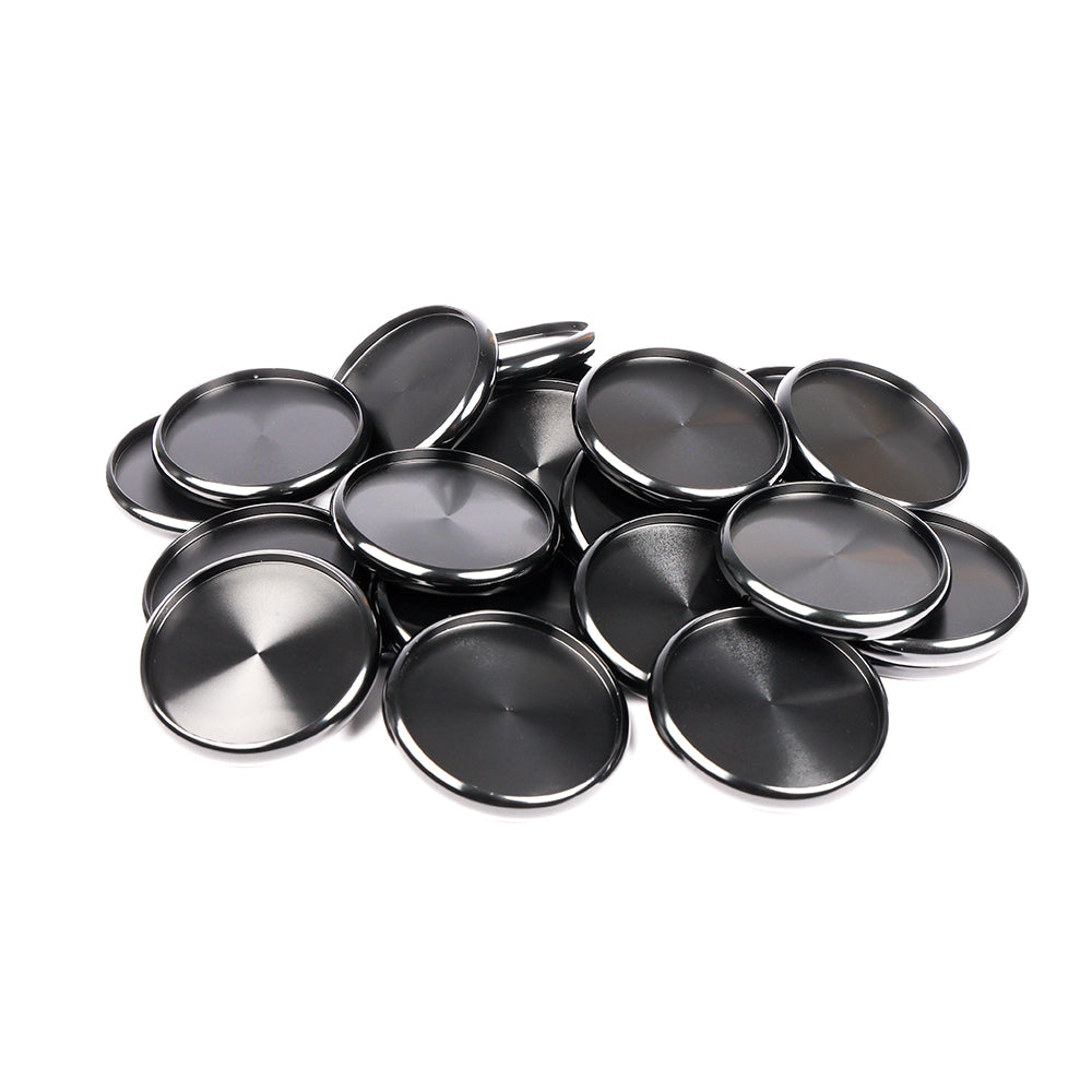 Ein Stapel glänzender, runder Alexandra Renke Bindescheiben aus Metall, die üblicherweise für Buchbinden verwendet werden, sind übereinandergelegt und auf einem weißen Hintergrund angeordnet.