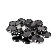 Ein Stapel glänzender, runder Bindescheiben (Kappen) aus schwarzem Metall von Alexandra Renke auf weißem Hintergrund, wesentliche Bindeelemente, die oft für Buchbinden verwendet werden.