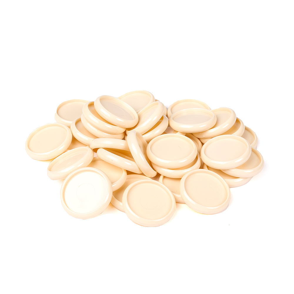 Ein Haufen runder, beigefarbener Alexandra Renke Bindescheiben-Deckel ist auf einem weißen Hintergrund verstreut.