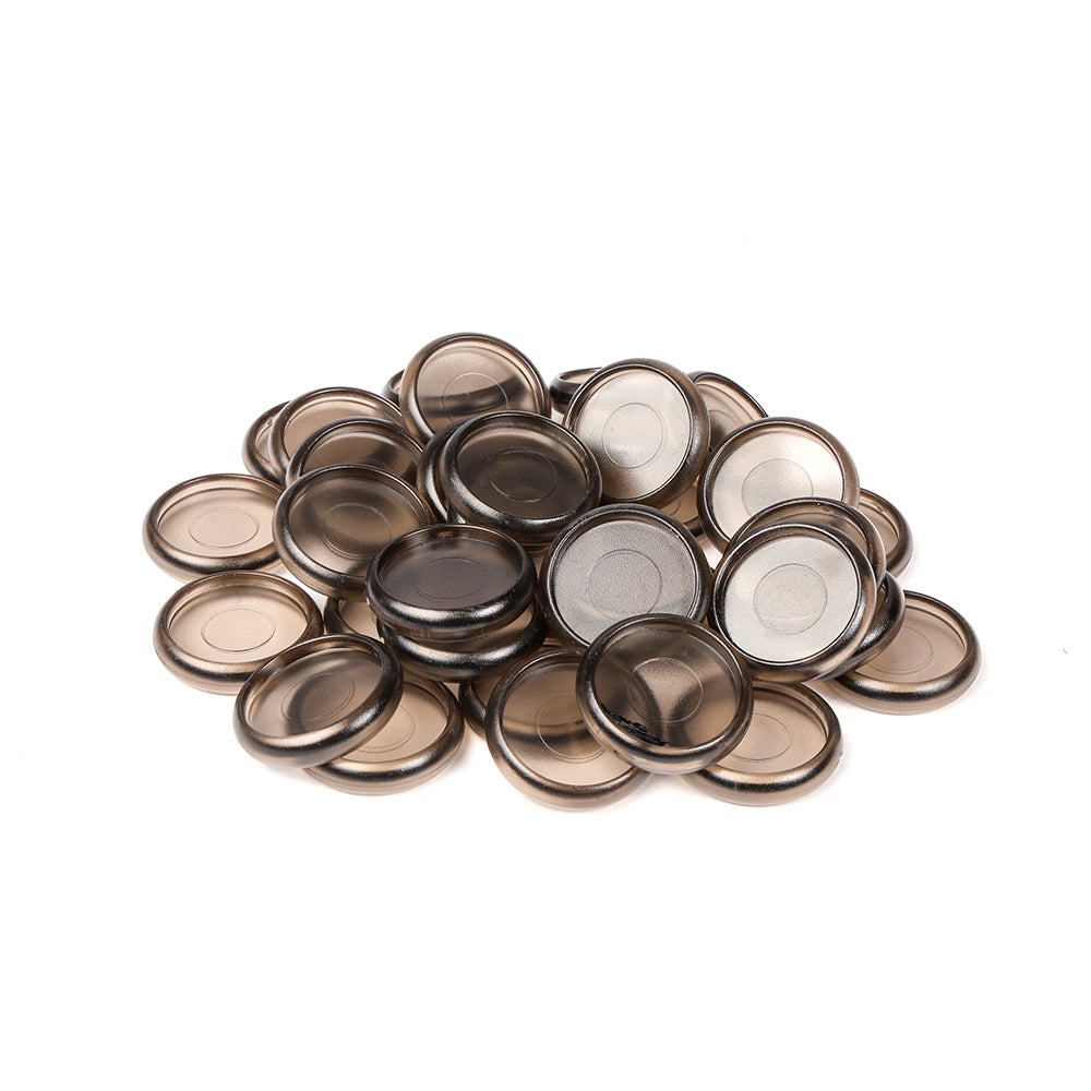 Ein Stapel runder, durchscheinender brauner Bindescheiben von Alexandra Renke, die oft als Bindeelemente für ein Mini-Album verwendet werden, ruht auf einem weißen Hintergrund.