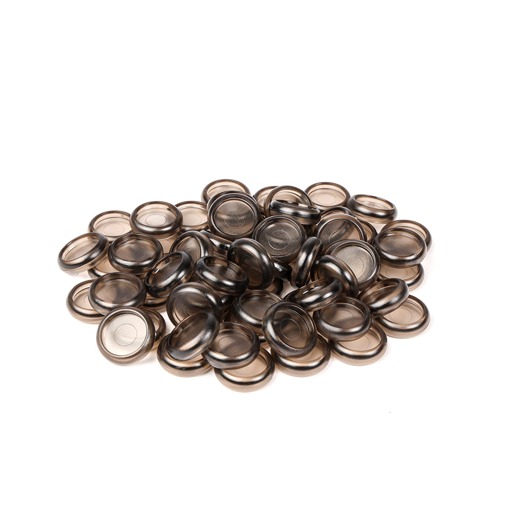 Ein Stapel runder, durchscheinender brauner Kunststoff-Bindekappen von Alexandra Renke, ideal für Buch binden, auf weißem Hintergrund.