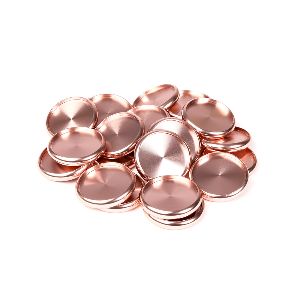 Ein Stapel glänzender, runder, roségoldener Metallscheiben von Alexandra Renke auf weißem Hintergrund.