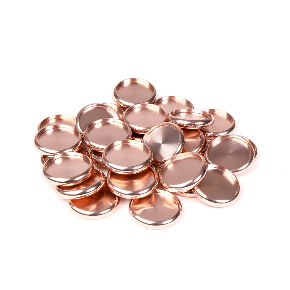 Ein Stapel glänzender, runder, roségoldfarbener Alexandra Renke Bindescheiben aus Metall auf weißem Hintergrund.