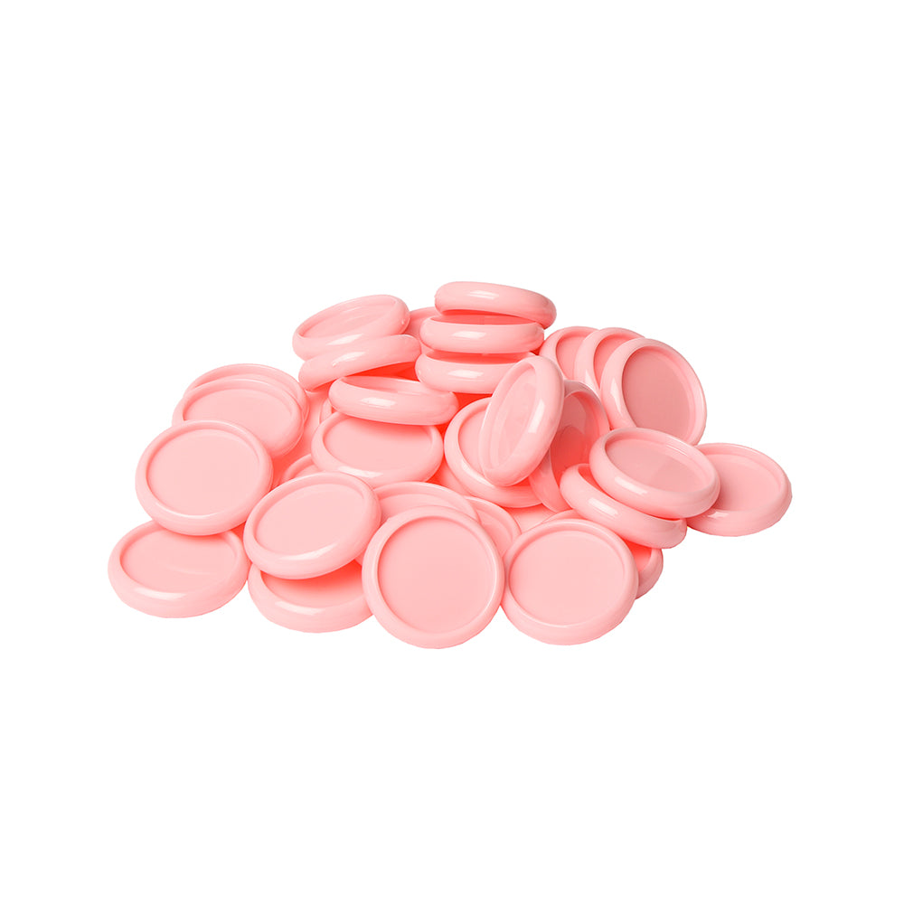 Ein Stapel runder, rosafarbener Alexandra Renke Bindescheiben aus Kunststoff auf weißem Hintergrund.