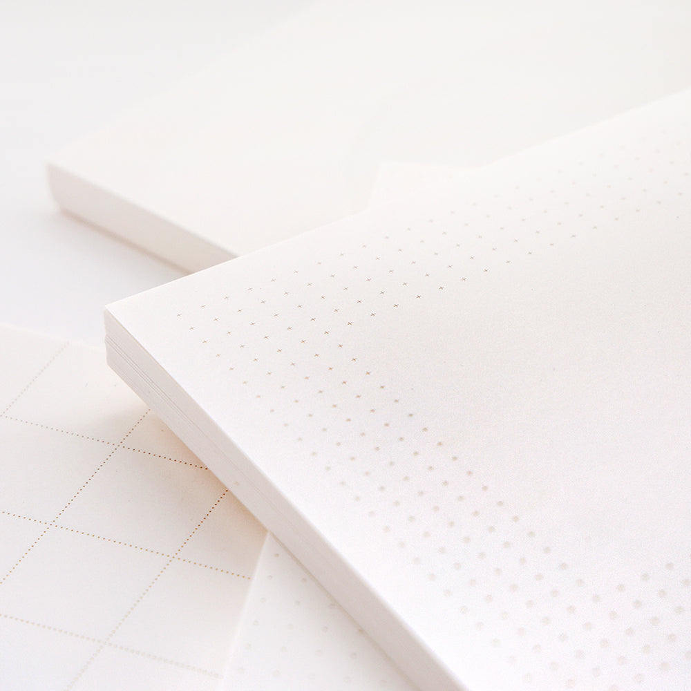 Nahaufnahme der losen Blätter von Alexandra Renke mit subtilen Punkt- und Gittermustern, perfekt für Bullet Journal oder Notizblock, auf hellem Hintergrund.