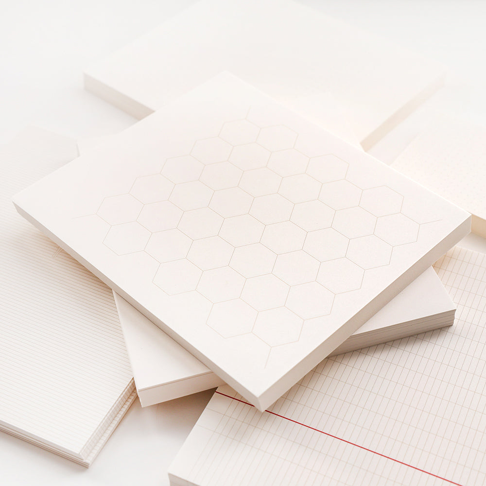 Ein Stapel weißer loser Blätter von Alexandra Renke Notizblock mit Raster-, Linien-, Punkt- und Sechseckmustern - perfekt für Bullet-Journal-Fans, die eine flexible Organisation suchen.
