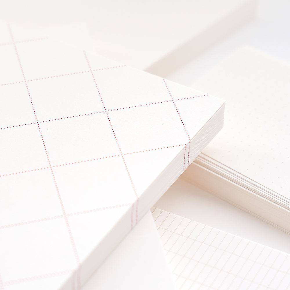 Stapel von Alexandra Renke Notizblöcken in Weiß mit verschiedenen Raster- und Punktmustern - ideal für Bullet-Journal-Aufbauten - in einer Nahaufnahme.
