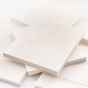 Mehrere weiße Alexandra Renke Notizblöcke mit verschiedenen Mustern und subtilen Linien sind auf einer weißen Oberfläche gestapelt und verstreut, perfekt um Ideen zu organisieren oder Ihr nächstes Bullet-Journal zu beginnen.