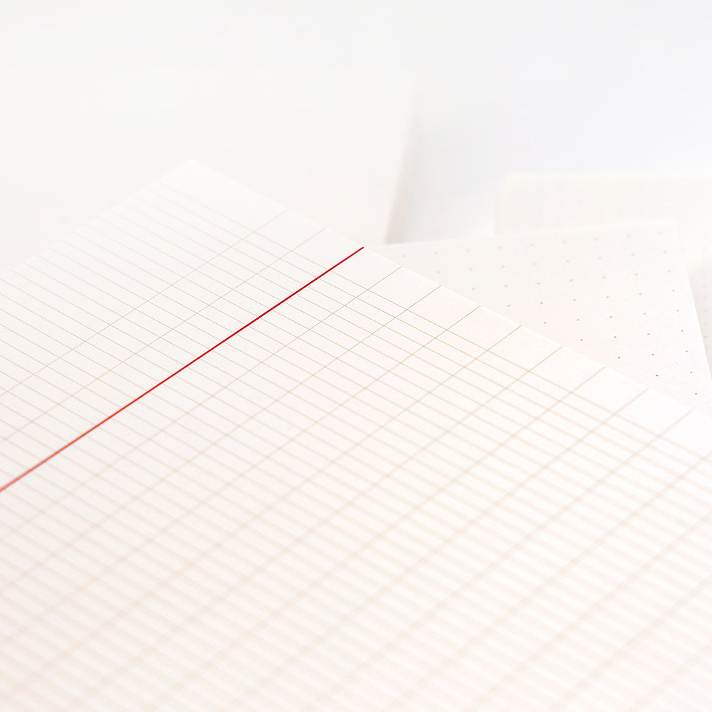 Nahaufnahme von Alexandra Renkes gestapelten Diagramm-, Punkt- und linierten Papierblättern - ideal für Bullet Journal-Fans oder als lose Blätter für Ihren Notizblock - auf weißem Hintergrund.