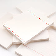 Stapel von Alexandra Renke Notizblöcken mit verschiedenen Linienmustern; der oberste Block hat einen roten und grauen diagonalen Streifenrand - ideal für Bullet-Journal-Fans oder zum Ordnen loser Blätter.