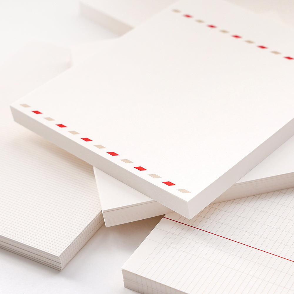 Stapel von Alexandra Renke Notizblöcken - einige mit roten und beigen Rändern, andere mit linierten Seiten und rotem Rand - ideal für Bullet Journaling oder um lose Blätter zu ordnen.