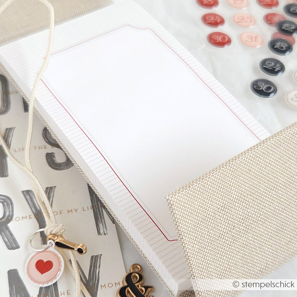 Flat Lay von Alexandra Renke Schreibwaren, mit einem leeren Notizblock für Ihr Bullet-Journal, nummerierten Knöpfen und farblich neutralen Accessoires.