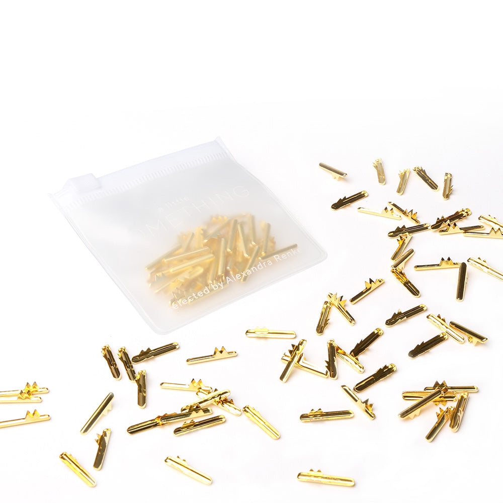 Alexandra Renke goldene Metallhaarnadeln und Splint werden neben einem durchsichtigen Beutel mit passenden Nadeln - ideal für Bastelarbeiten - auf einem weißen Hintergrund präsentiert.