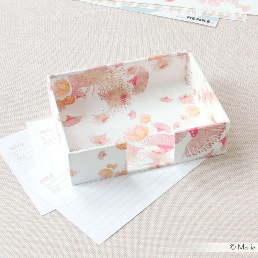 Eine dekorative Blumenschachtel im rosa-orangen Eukalyptusblüten-Design von Alexandra Renke ruht auf gefüttertem Briefpapier - ideal für kreatives Buchbinden oder als einzigartiges Bucheinbandpapier.
