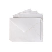 Vier weiße Umschläge aus passendem Papier, gefertigt aus handgeschöpftem Büttenpapier, auf einem weißen Hintergrund gestapelt – perfekt für elegante Hochzeitseinladungskarten.