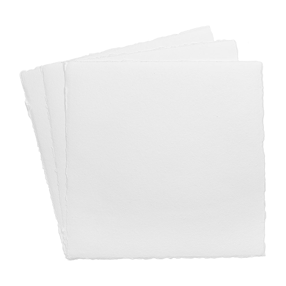 Drei quadratische Blätter handgeschöpftes Papier, die mit leicht ungleichmäßigen Rändern auf einem weißen Hintergrund übereinandergestapelt sind.